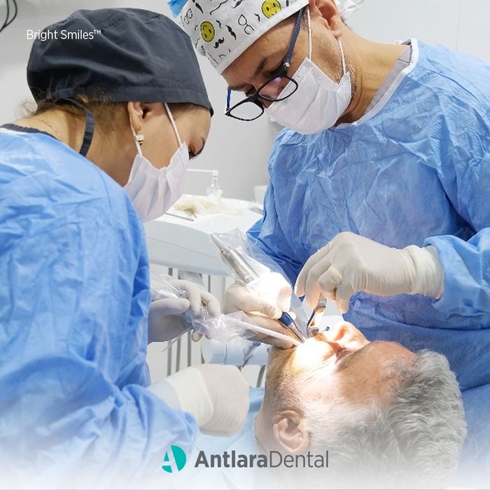 два стоматолога проводят операцию по установке зубных имплантатов
