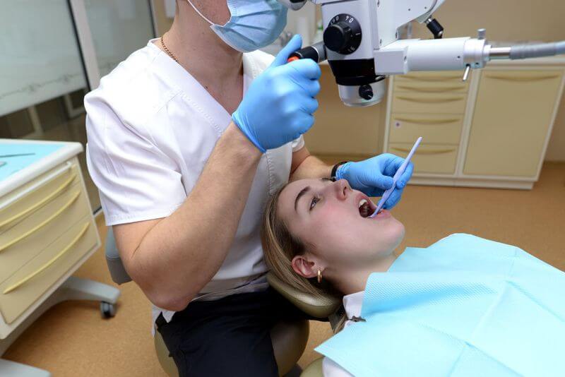 dentist checking women mouth with microscope in dental clinic located in Turkey