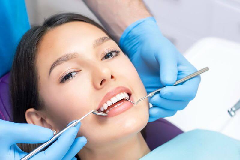 Diş beyazlatma işlemi için diş kliniğinde yatan kadın hasta
